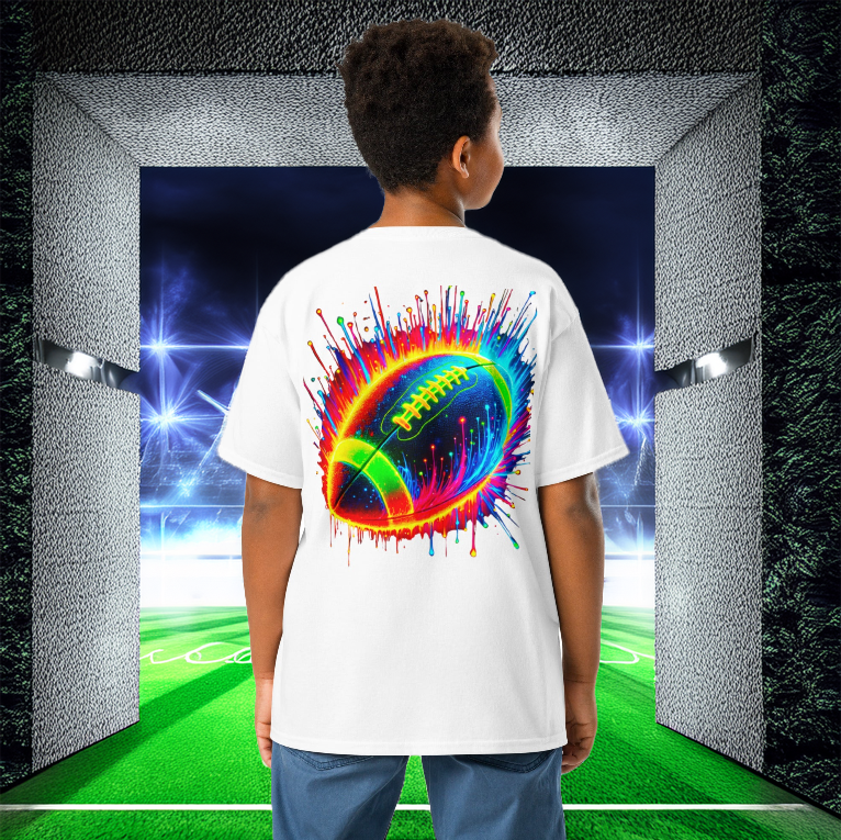 A young boy wears the Neon Gridiron Youth Tee in white, featuring a vibrant neon football explosion on the back. He stands in a high-tech football stadium tunnel, ready to step onto the field. The bold, electrifying design is perfect for young football enthusiasts who live for speed, energy, and the love of the game.