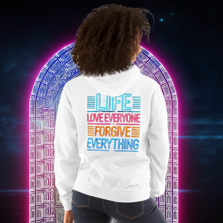 A woman wearing a white hoodie with a vibrant neon-style message on the back that says "LIFE - LOVE EVERYONE - FORGIVE EVERYTHING," standing before a glowing arched gateway.