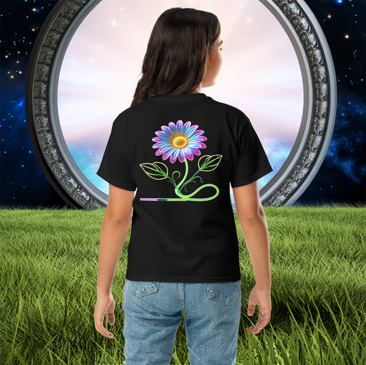Youth wearing a black tee featuring a neon-glowing daisy with a futuristic vine design, standing in front of a mystical portal with lush green grass and a cosmic sky.