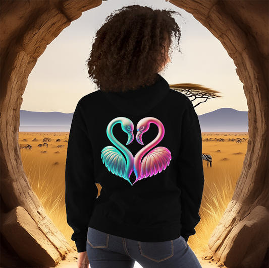 Woman wearing a black hoodie with a neon flamingo heart design, standing in front of a scenic savanna landscape. Stylish, comfortable, and unique hoodie fashion.