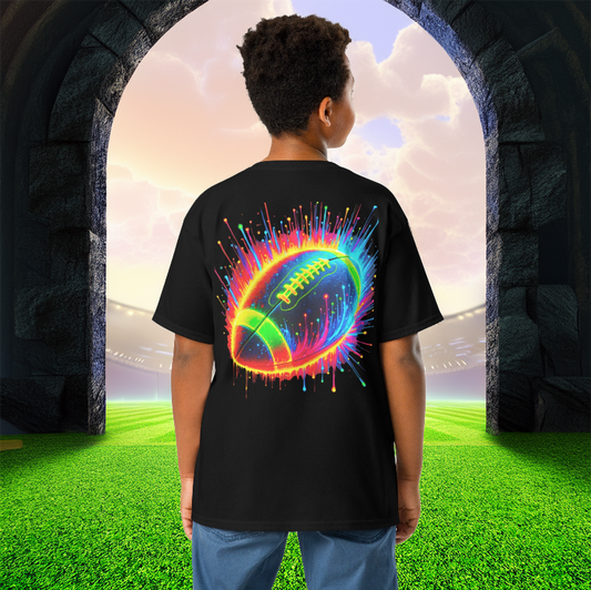 A young boy wearing the Neon Gridiron Youth Tee in black, featuring a vibrant neon football design bursting with energy. The tee is set against a majestic stadium entrance, symbolizing the thrill of the game. Perfect for young football enthusiasts who love bold, eye-catching sportswear.
