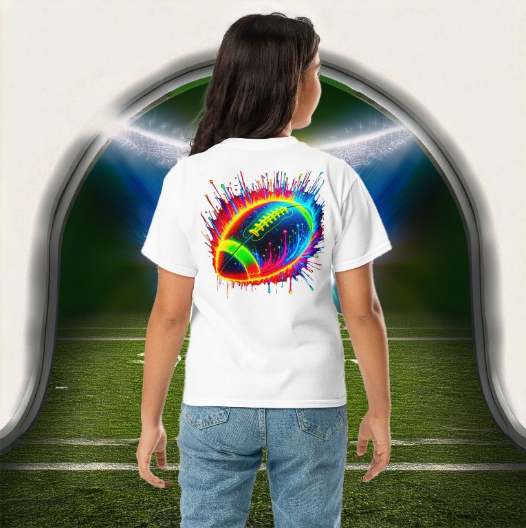 A young girl wearing the Neon Gridiron Youth Tee in white, featuring a vivid neon football explosion design, symbolizing power and action. She stands at the entrance of a futuristic football stadium, ready for game day. Perfect for young football fans who love bold, high-energy sportswear.