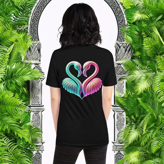 Female model wearing the Eternal Unity Tee in black, showcasing a vibrant neon flamingo heart design on the back. The mystical arched gateway surrounded by lush green foliage creates a dreamy paradise aesthetic, symbolizing love, harmony, and connection.