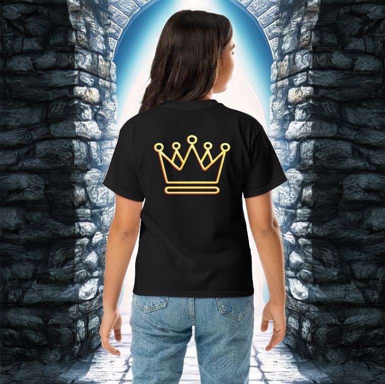 A young girl wearing a white t-shirt with a neon gold crown design on the back, standing between ancient stone walls illuminated by golden sunlight.