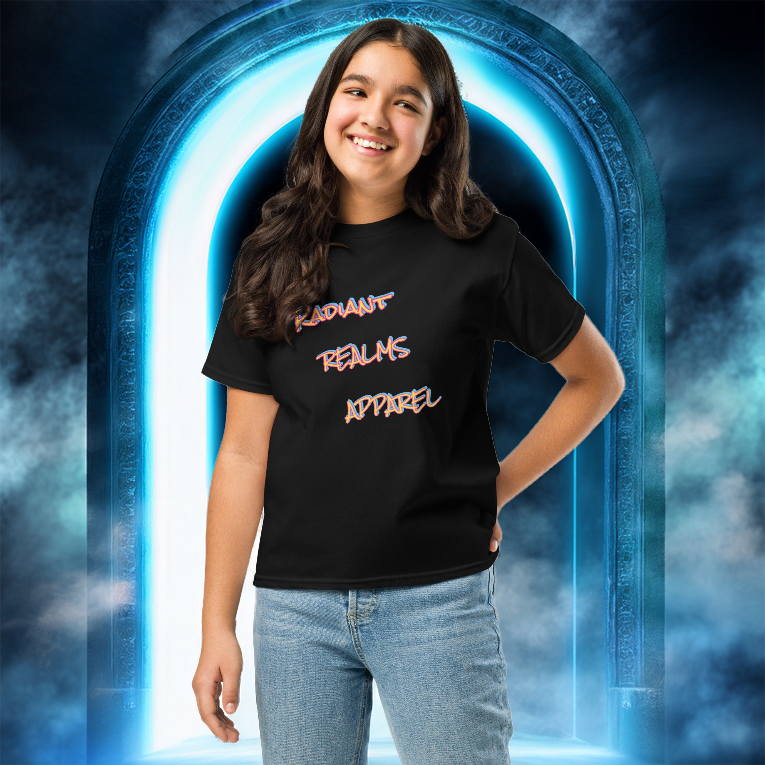 Smiling young girl wearing a black 'Radiant Realms Apparel' youth tee, standing confidently in front of a glowing blue mystical portal surrounded by swirling mist.